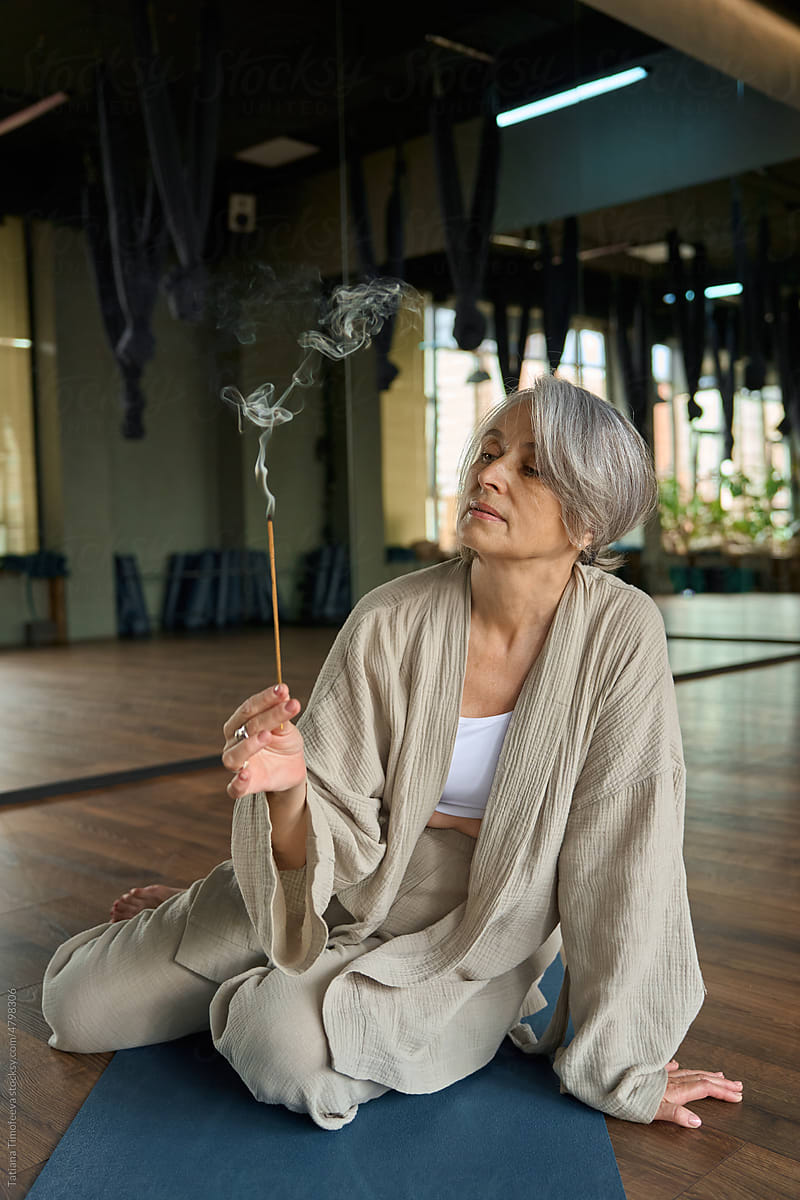adult woman in yoga center burning aroma sticks