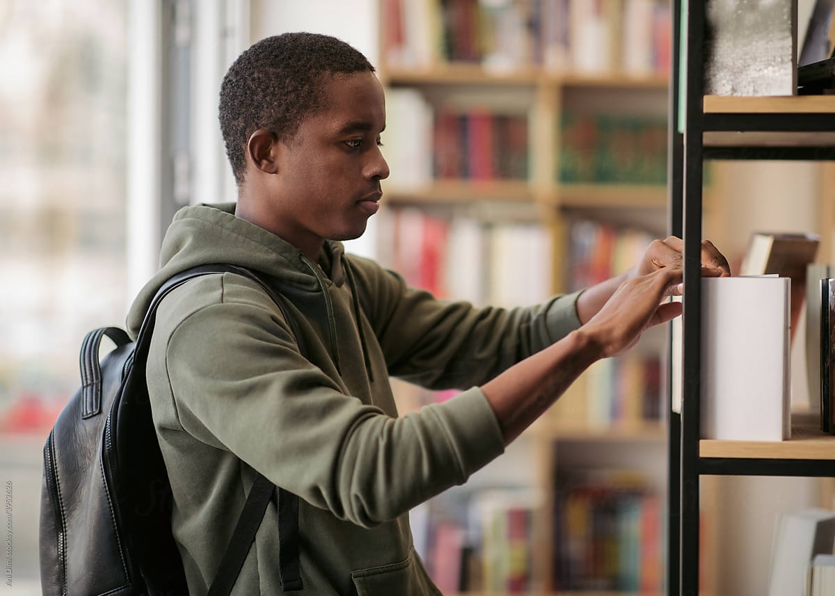 Student Taking A Book From The Shelf