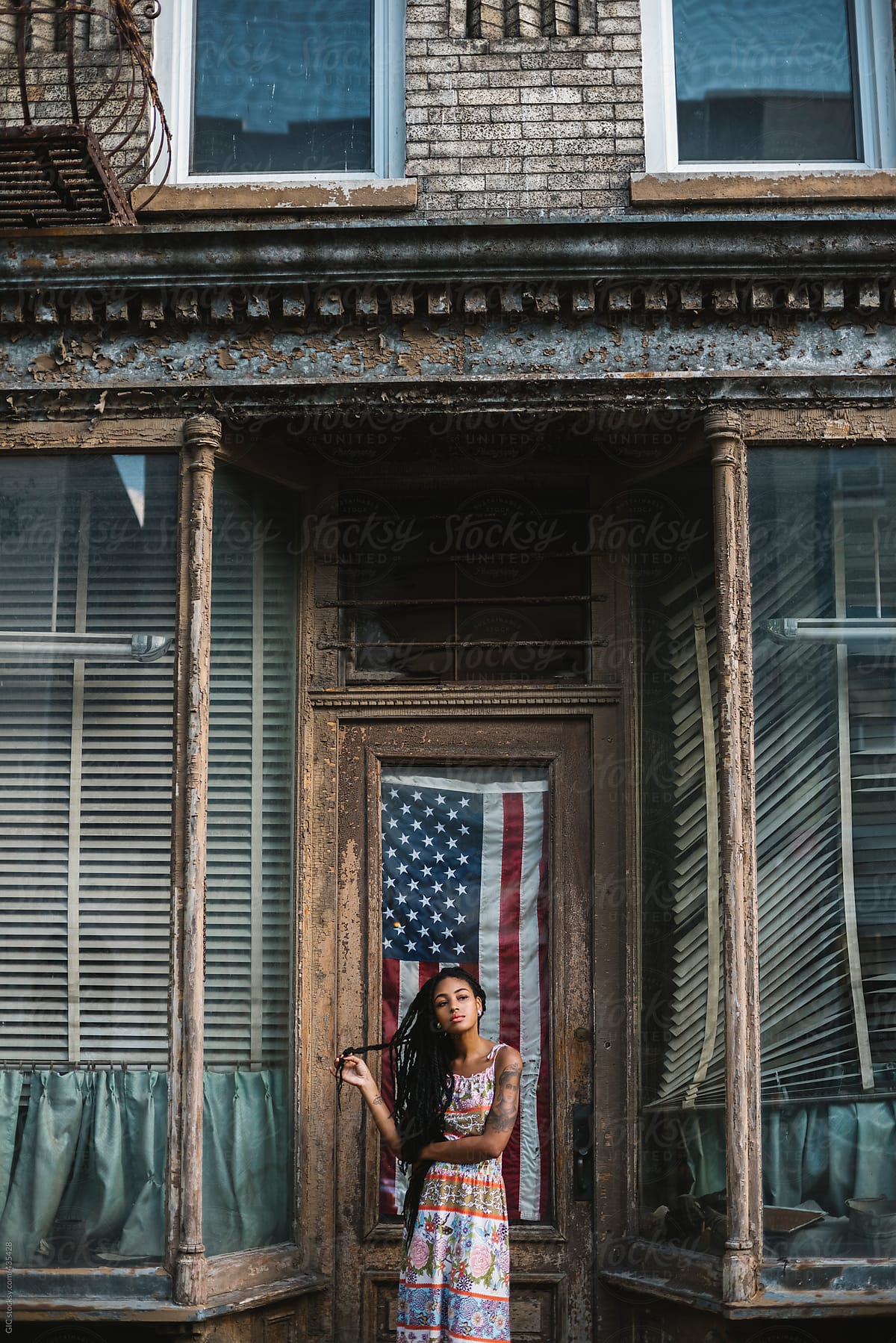 Woman against old house and USA flag