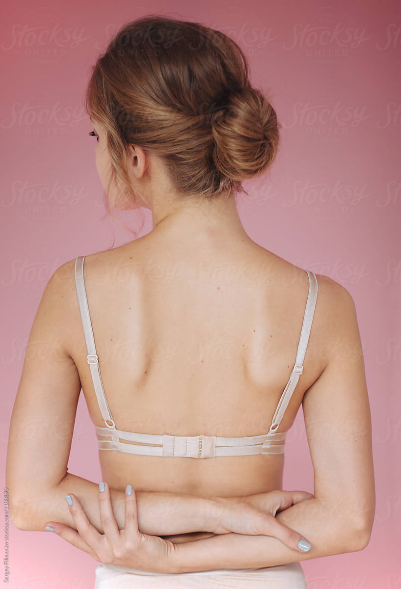Woman in bra posing on pink background