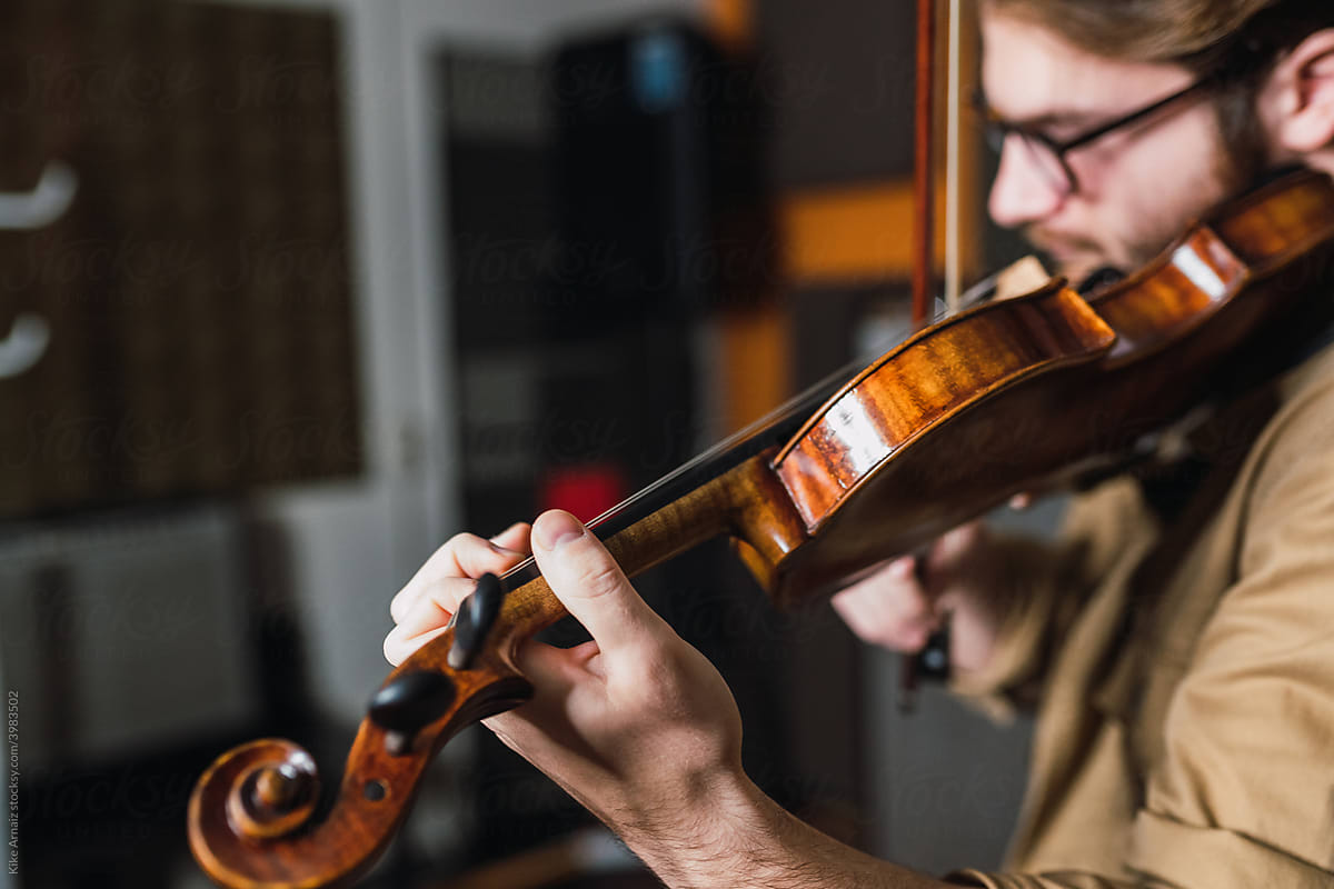 Man playing on violin in studio