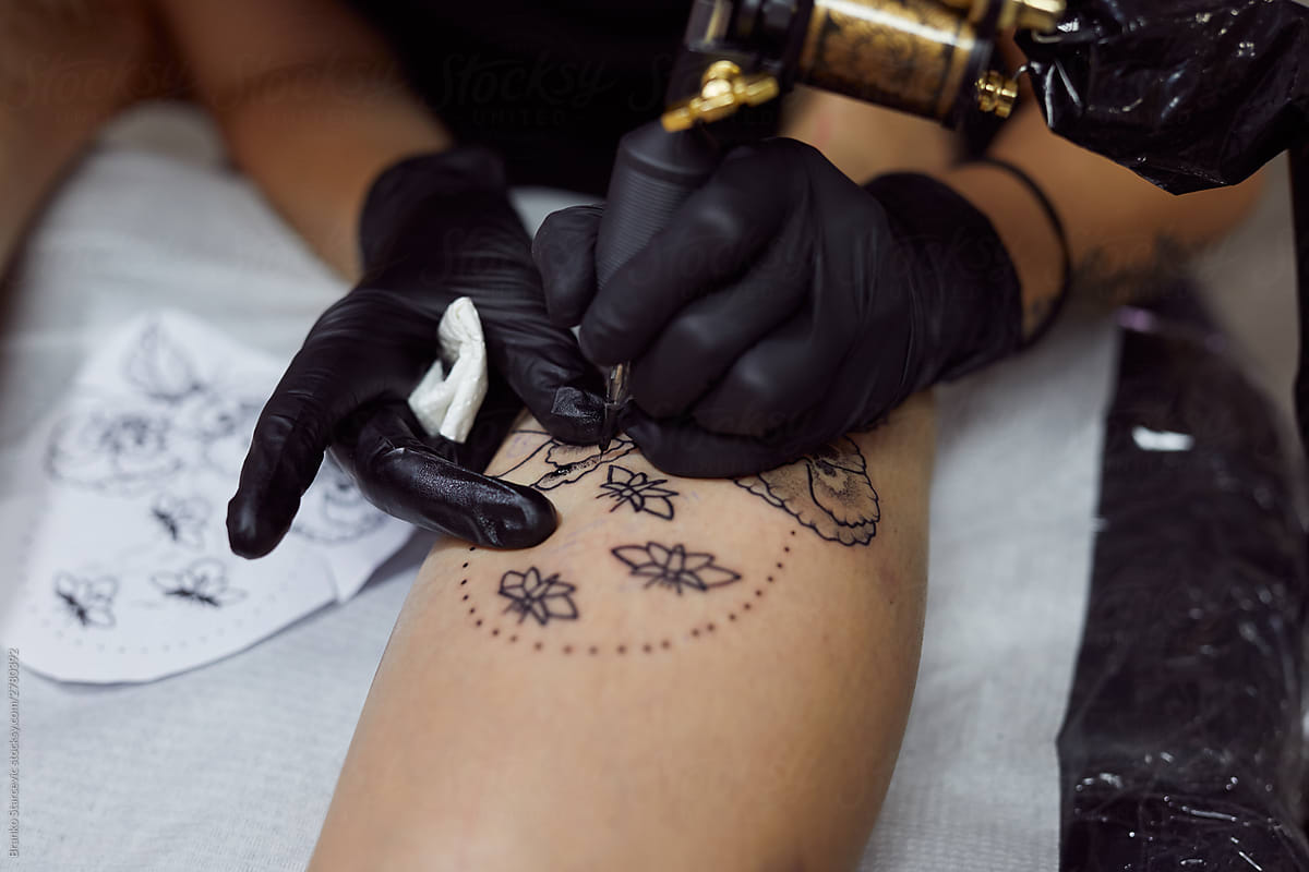 Close up of female tattoo artist working.