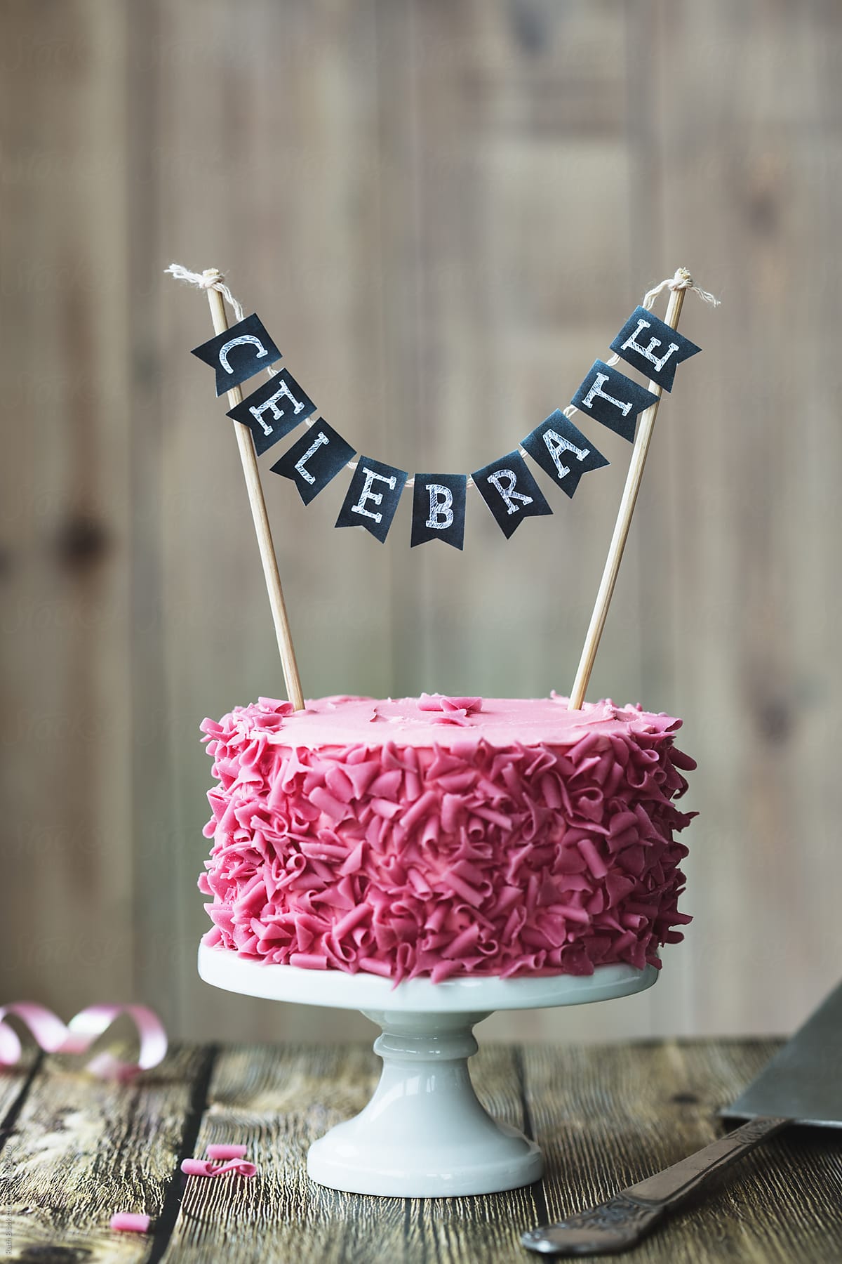 Cake with pink chocolate curls and  banner reading 