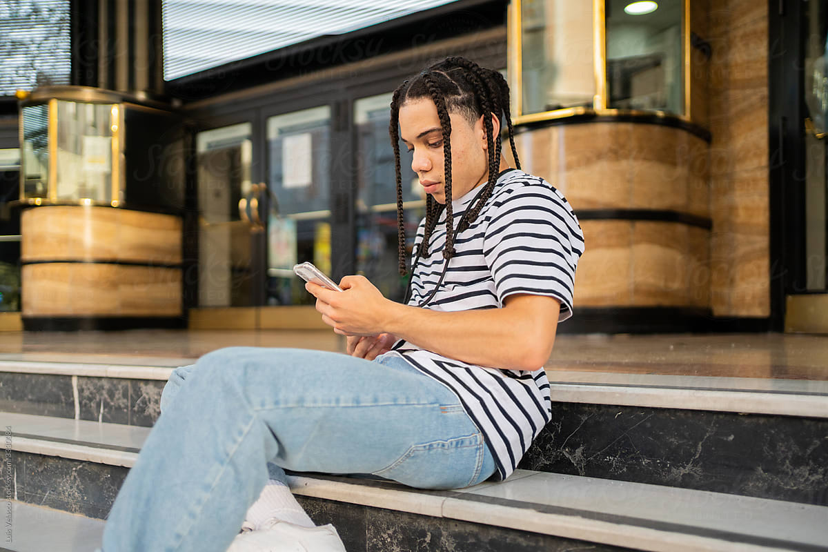Young Boy Texting On The Streets.