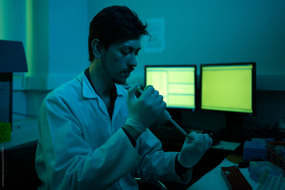 Scientist Working In A Dark Laboratory Next To The Computer.