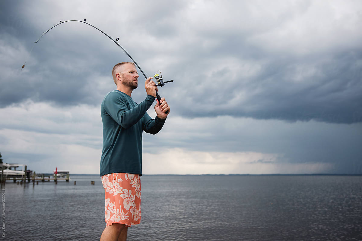 Man Casting A Fishing Pole by Stocksy Contributor Kelly Knox