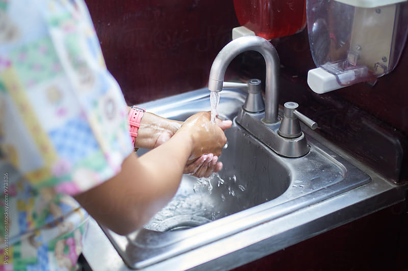 A nurse washing her hands in a hospital
