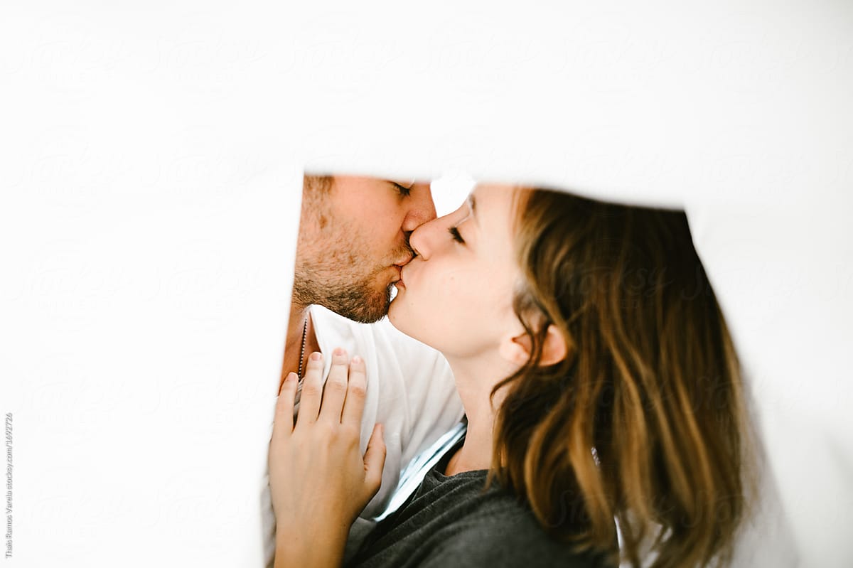 Young Couple Kissing Under The Sheets By Stocksy Contributor Thais