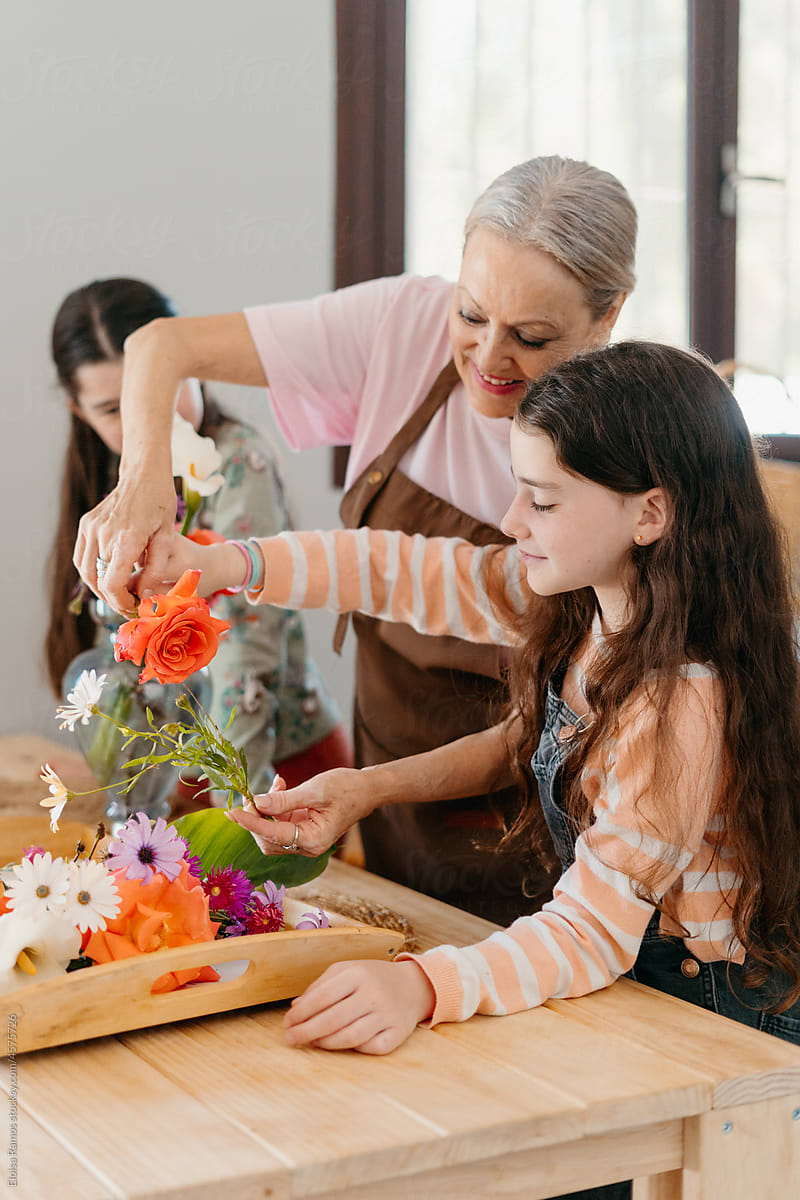 Grandmother and granddaughters preparing floral decoration