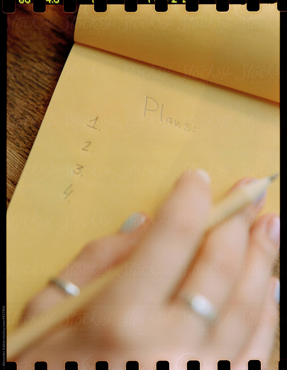 Female hand writes in a notebook