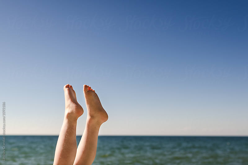 Young kid\'s feet up in the air by the lake