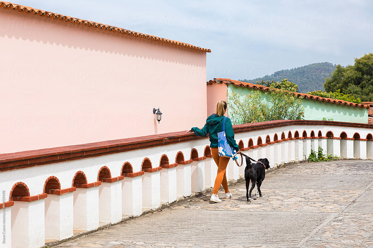 Woman walking with her dog in a village