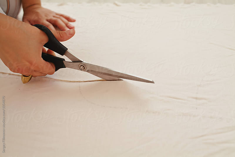 seamstress cuts fabric with scissors