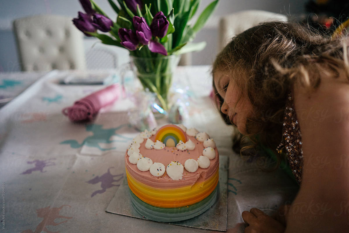 Little girl with birthday cake at home