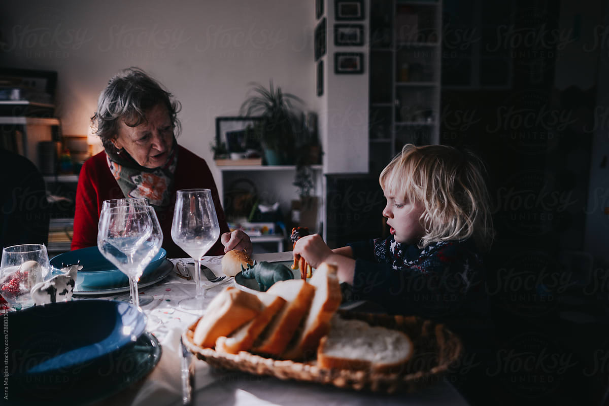 "A Grandson With His Granny Having Dinner" by Stocksy Contributor "Anna