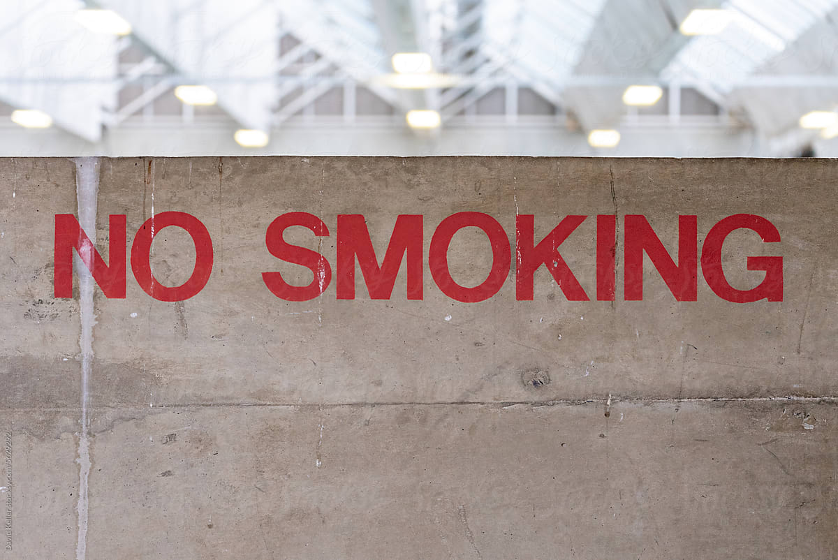 A hand-painted no smoking sign in a large building