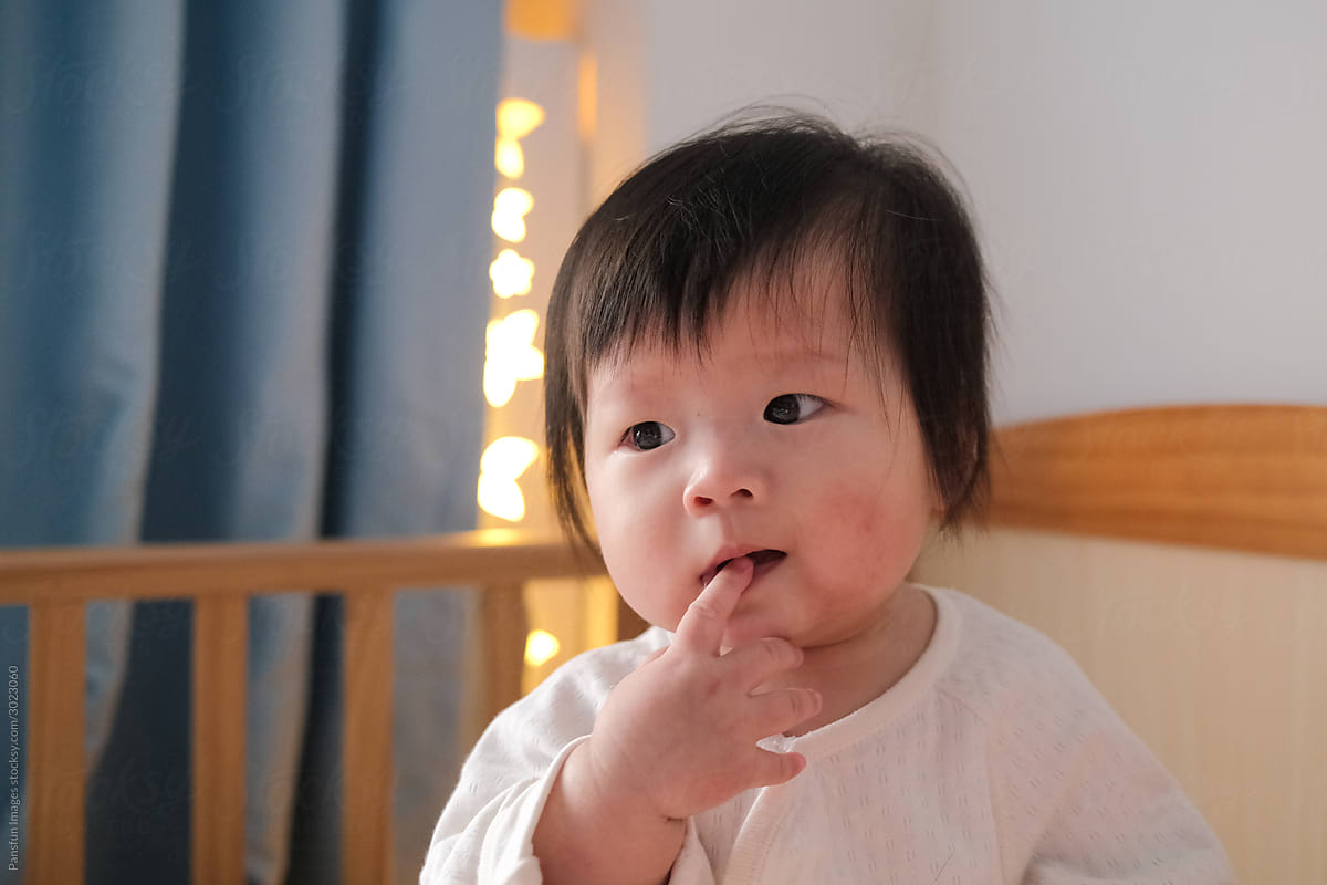 cute Asian baby licking fingers
