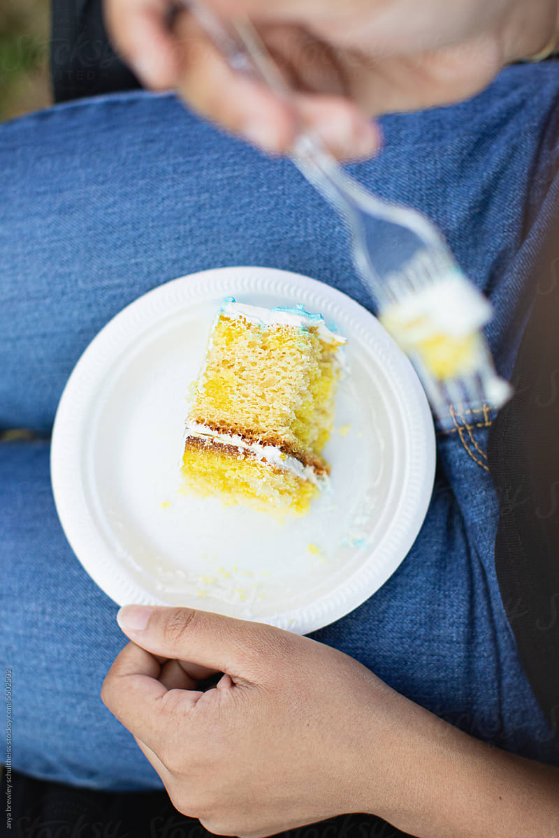 Slice of cake on a white plate being  eaten, being eaten.