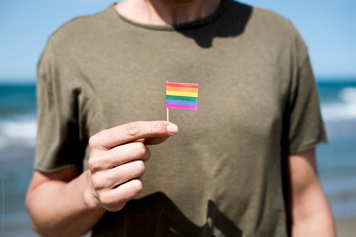 man with a small gay pride flag