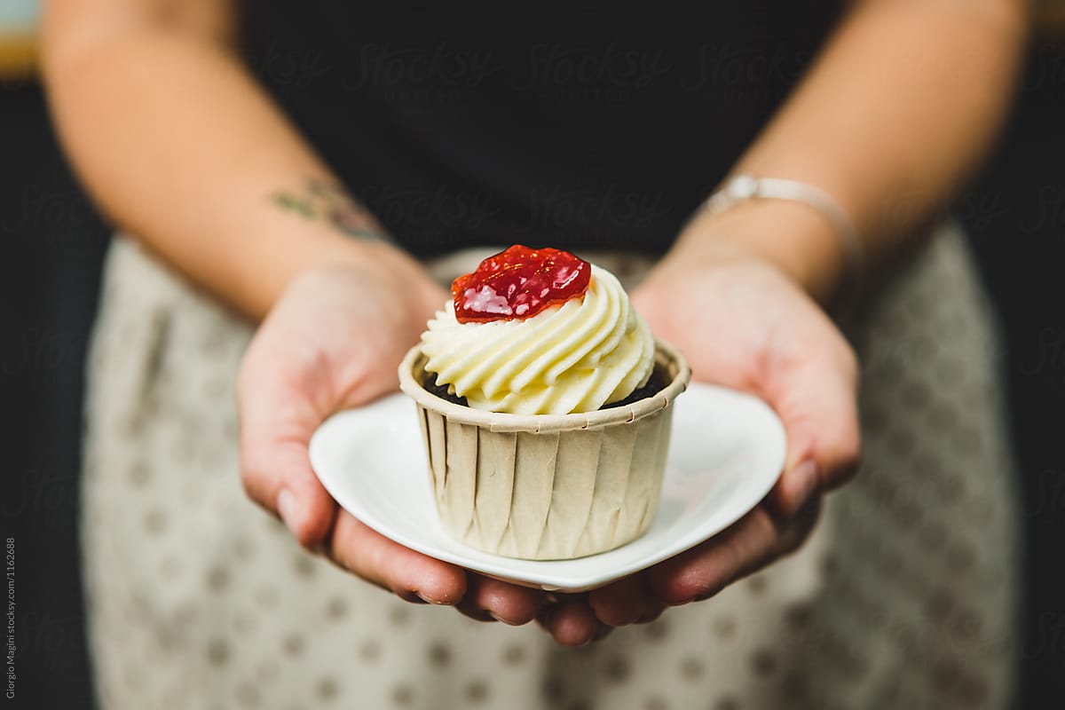 Woman Holding a Small Plate with a Cupcake