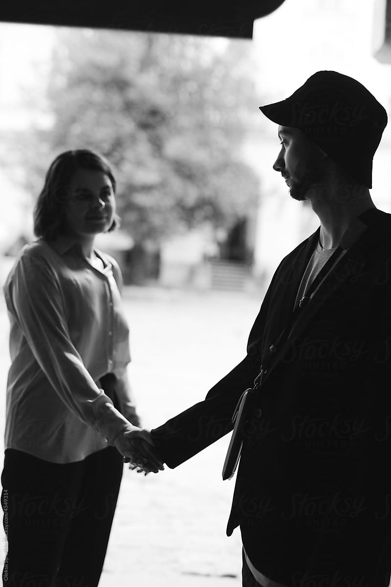 Monochrome of young couple holding by hands and looking at each other