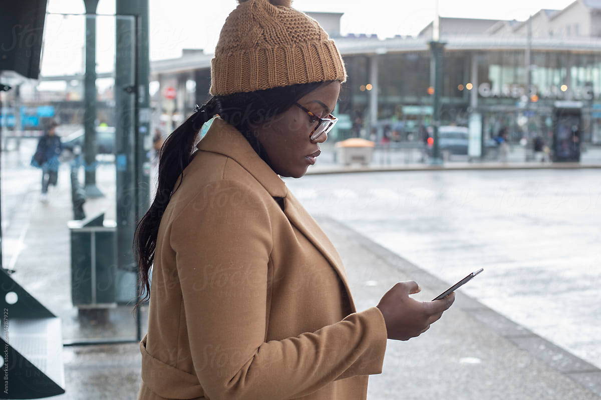 commuting, black woman using smartphone on bus stop, transport