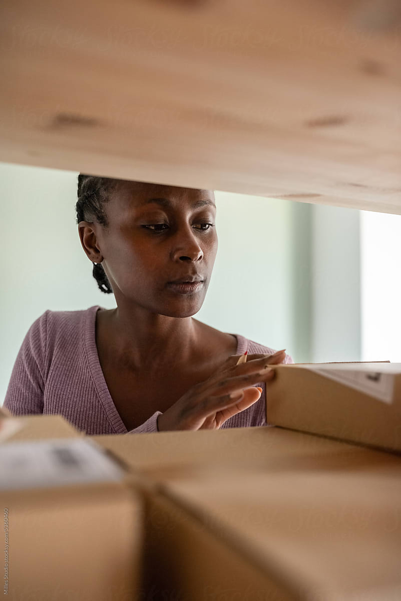Black woman examining information on parcels