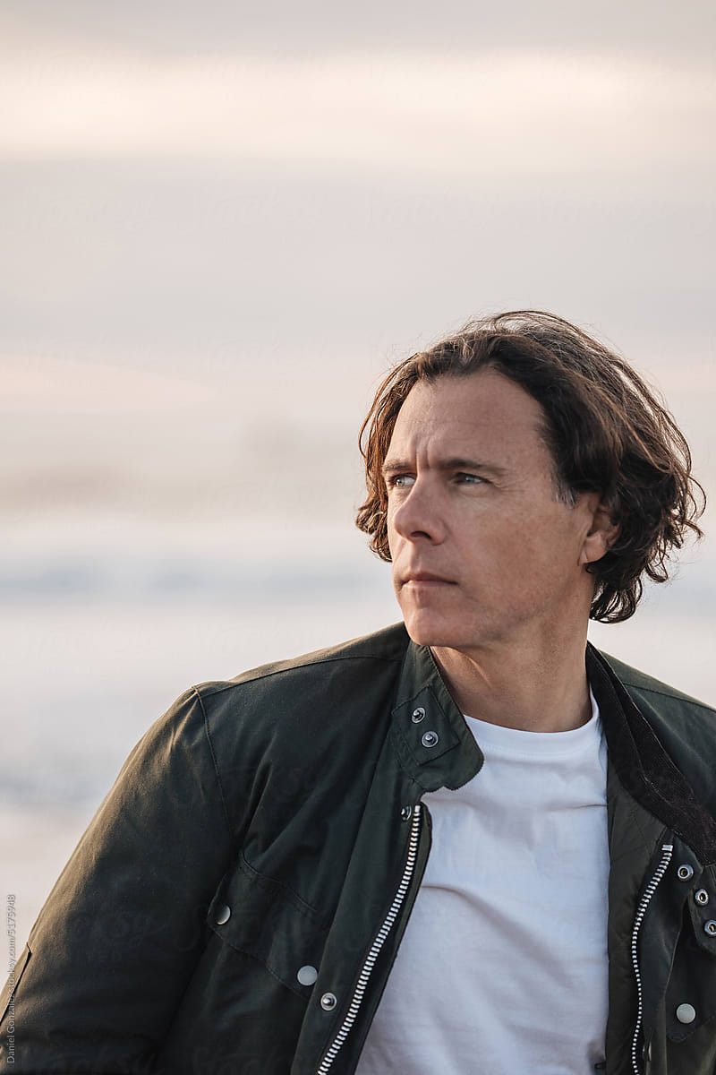 Thoughtful man in leather jacket on beach