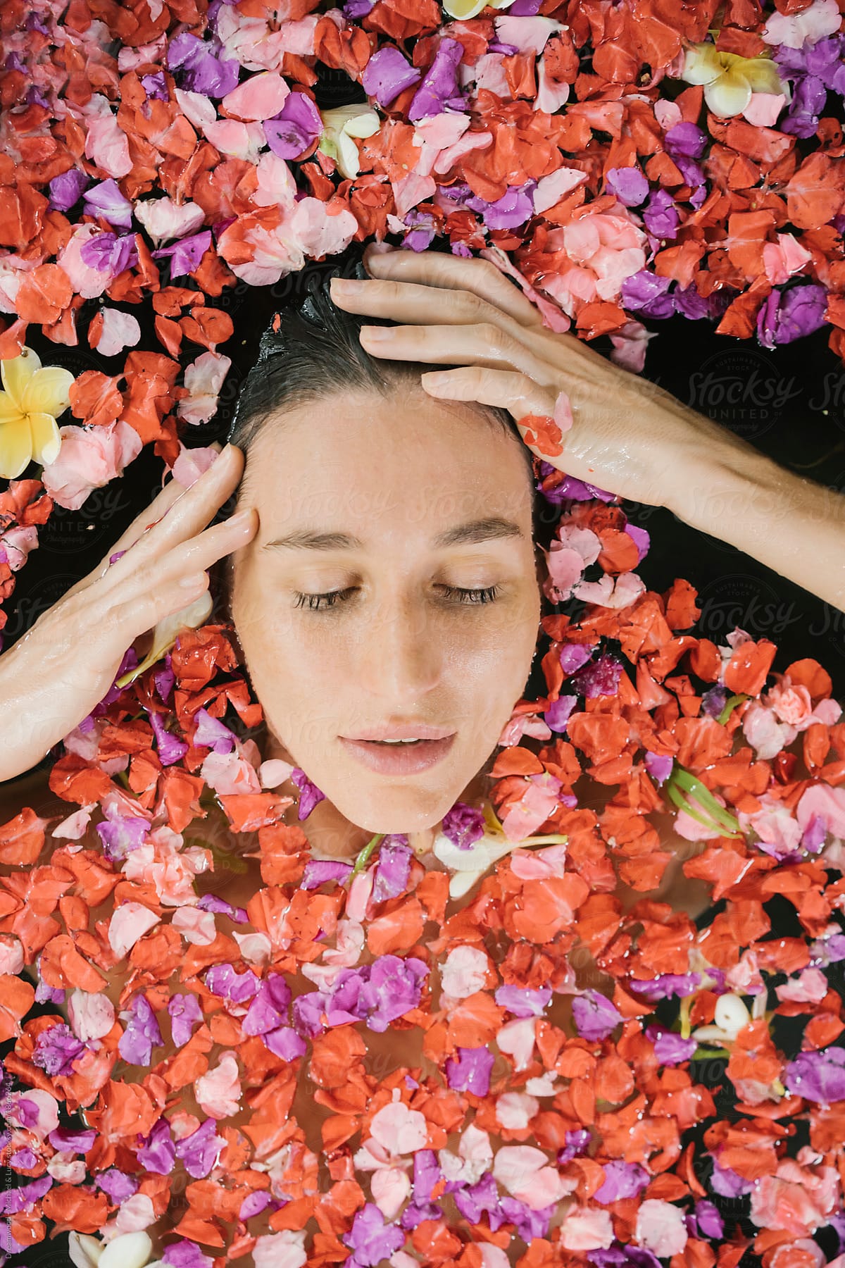 Woman lying in water with petals