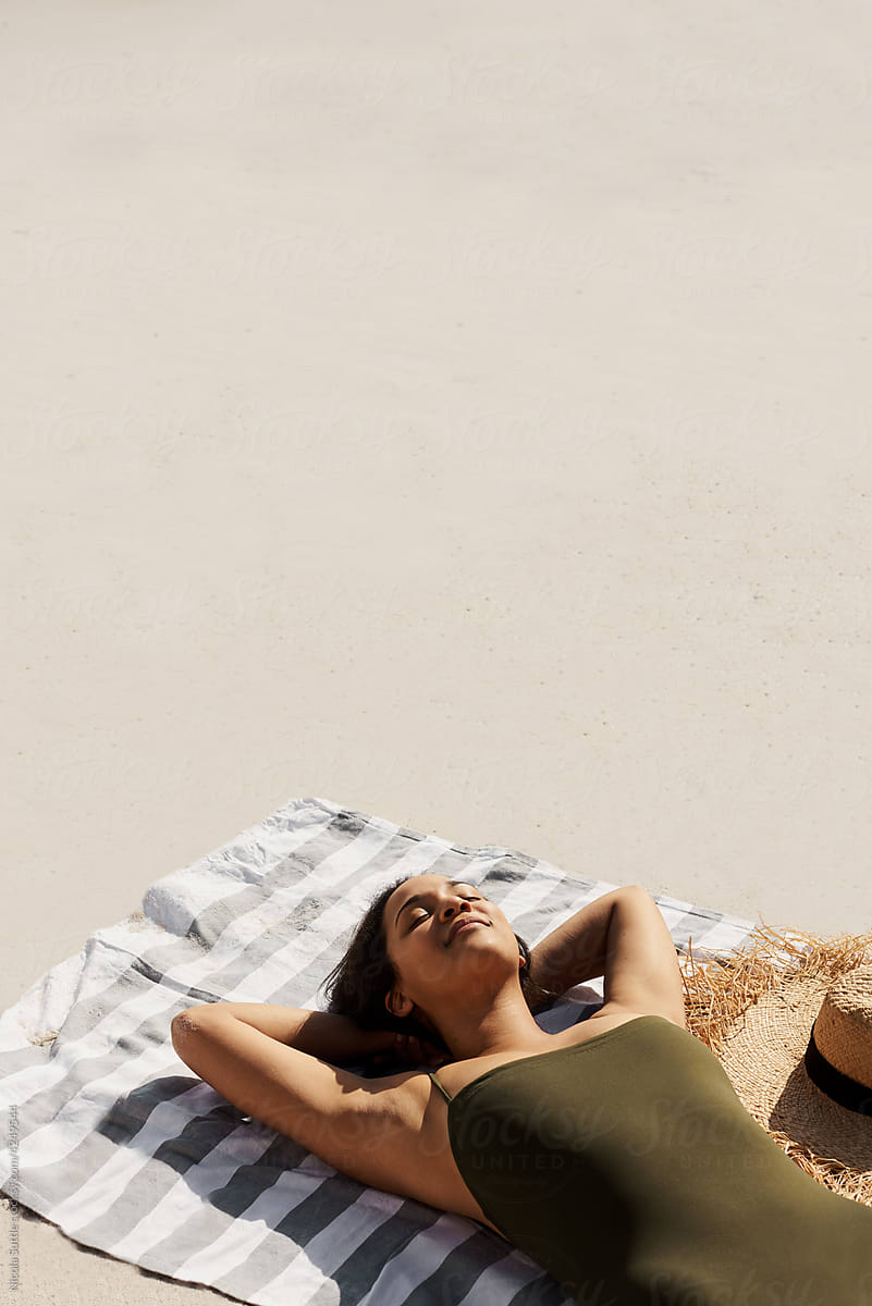 Relaxed woman sunbathing on sunny beach
