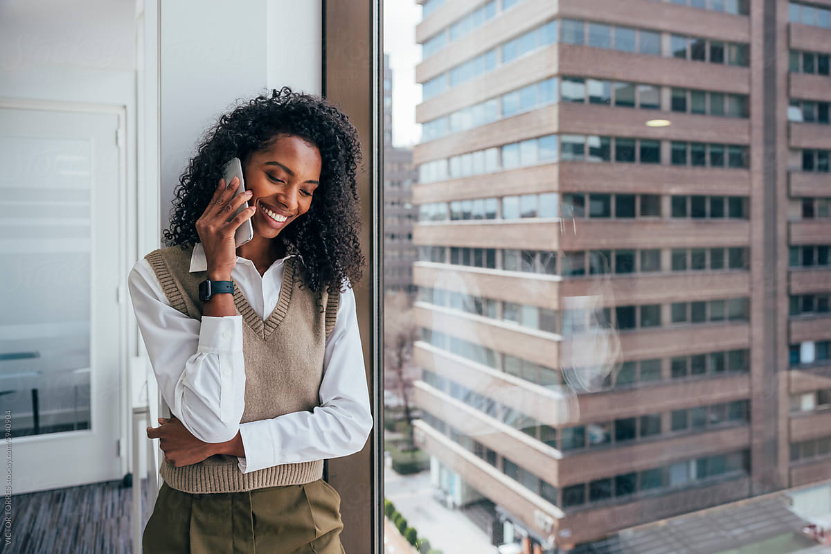 Smiling black businesswoman taking a call in office setting