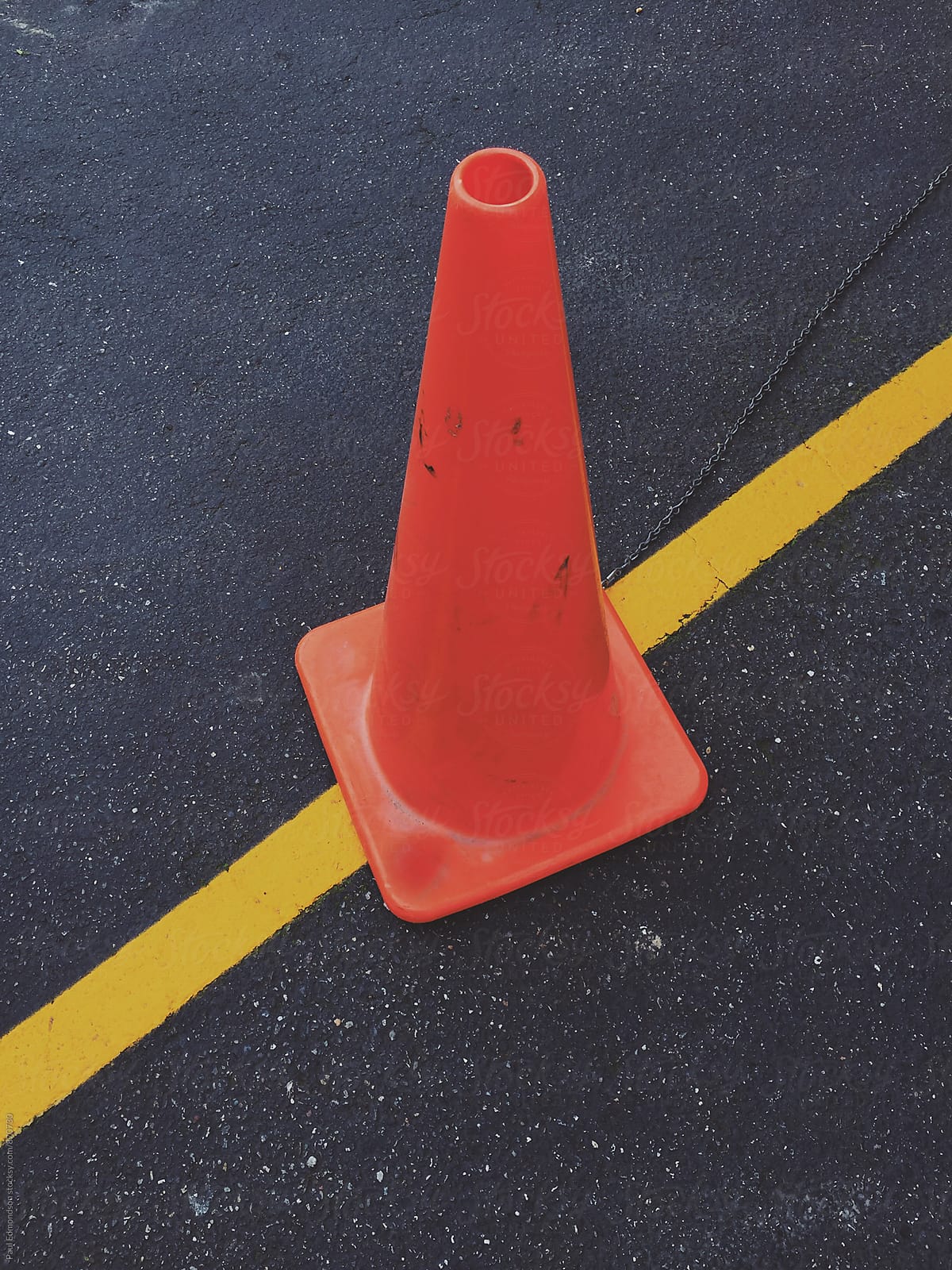 Traffic cone and yellow boundary line on road