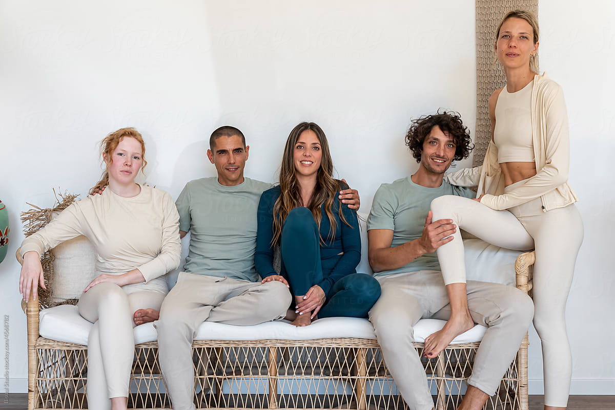 Group of diverse friends sitting on sofa in yoga studio