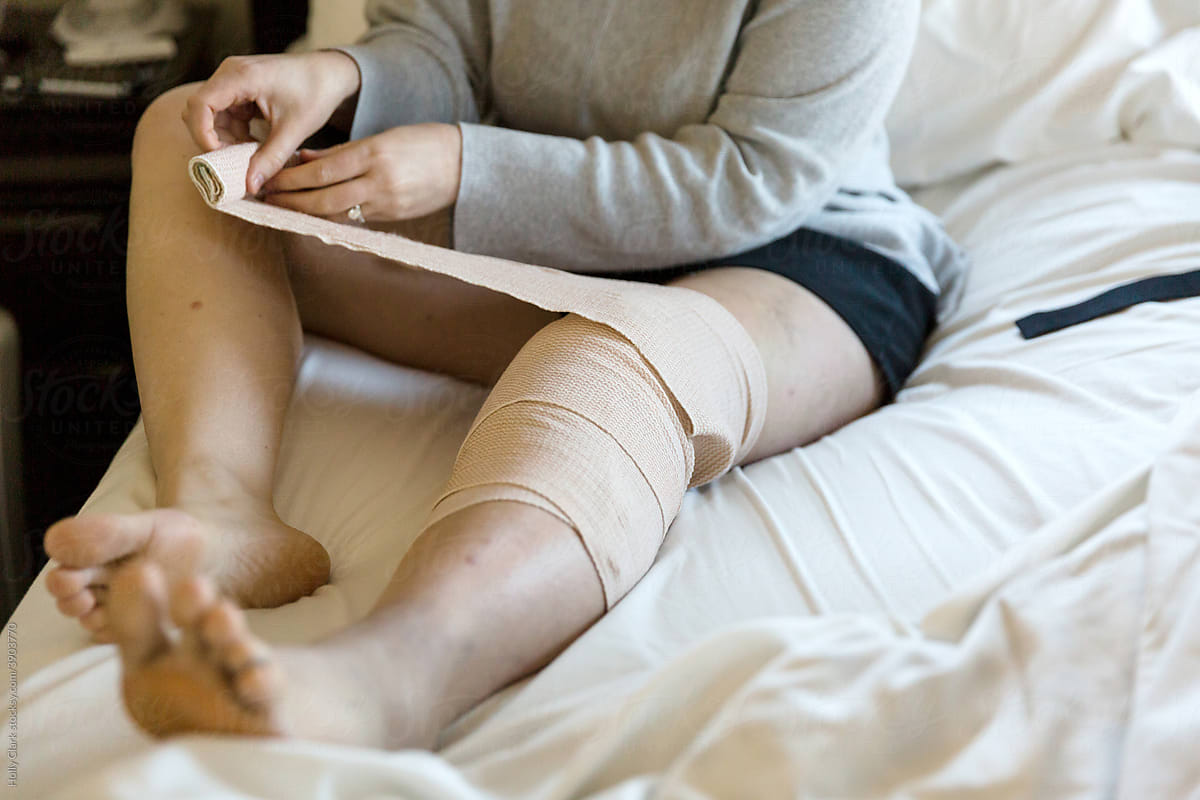 Woman wraps knee with bandage