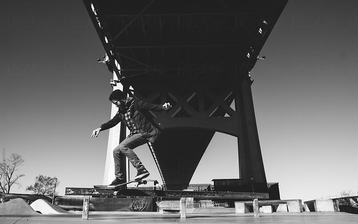 Skateboarder under bridge
