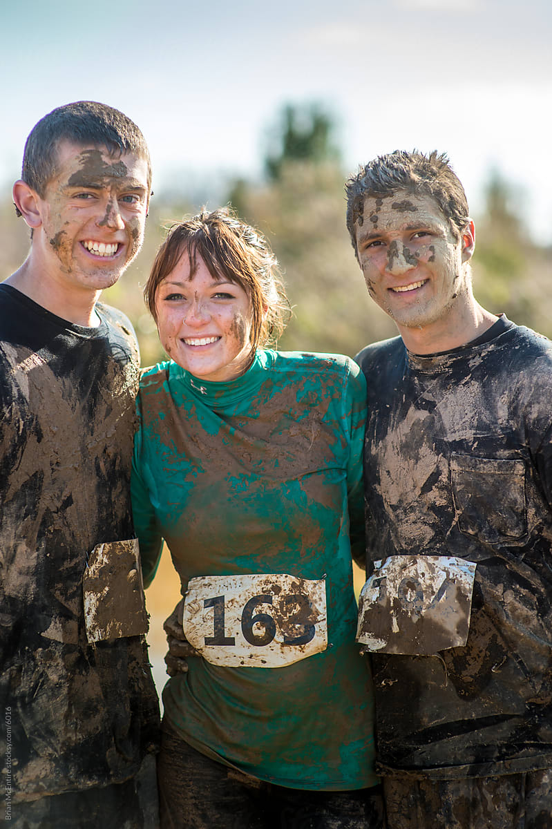 Teammates Cheerful Portrait After Mud Endurance Challenge