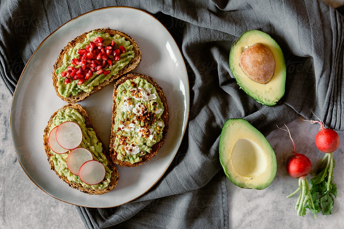 Avocado sandwiches with pomegranate seeds, radish and white cheese