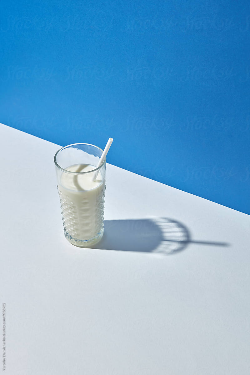 Organic milk in a glass with papercraft straw.