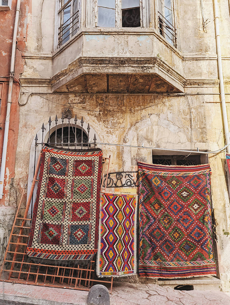 Turkish rugs hang against a building