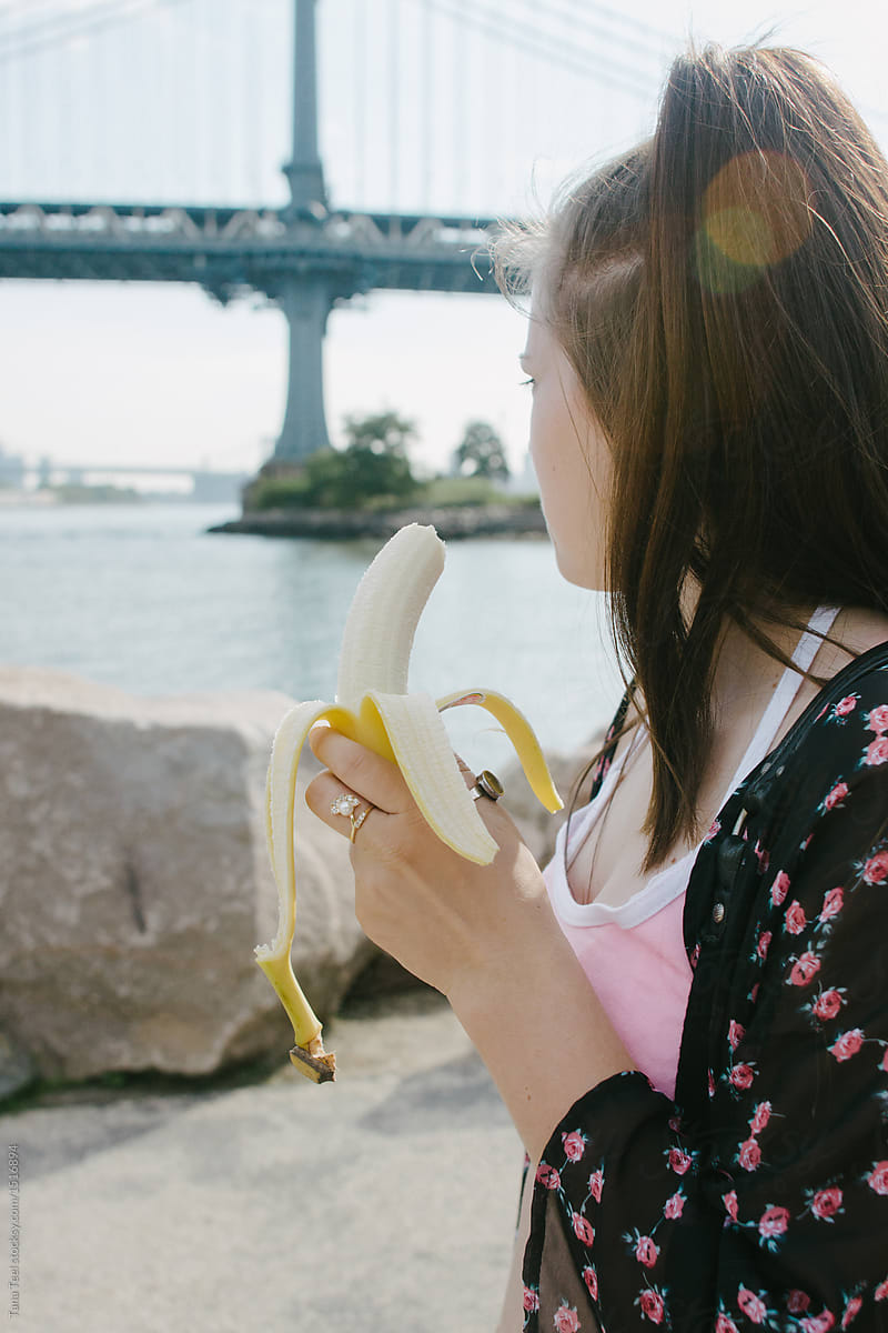 young woman eating a banana at Dumbo park in Brooklyn
