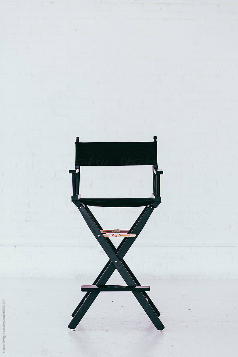Black director\'s chair in a bright and airy white brick warehouse