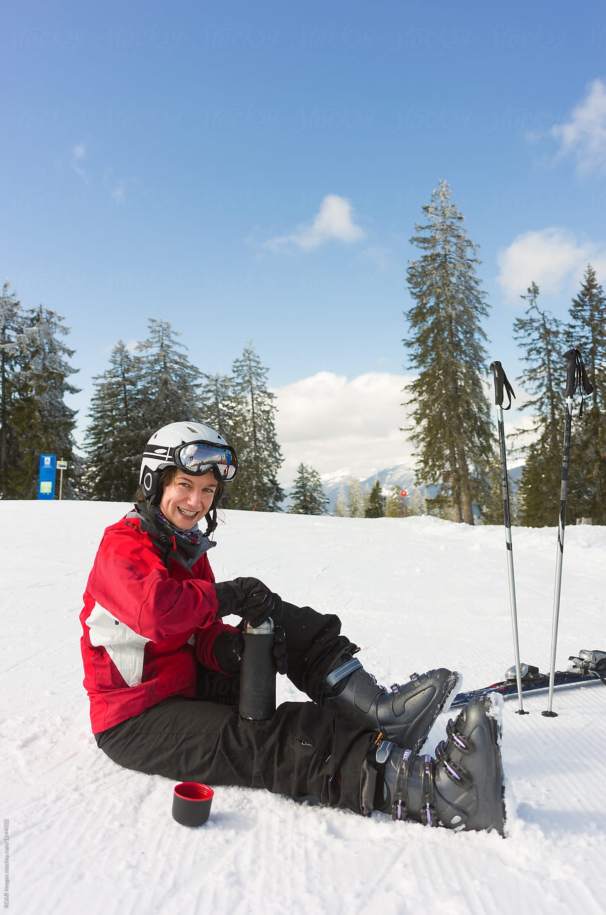 Woman resting on the ski piste on a sunny day