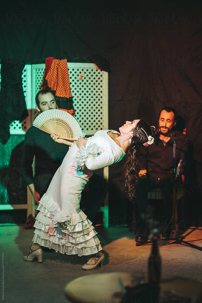 Woman dancing flamenco while musical band playing music