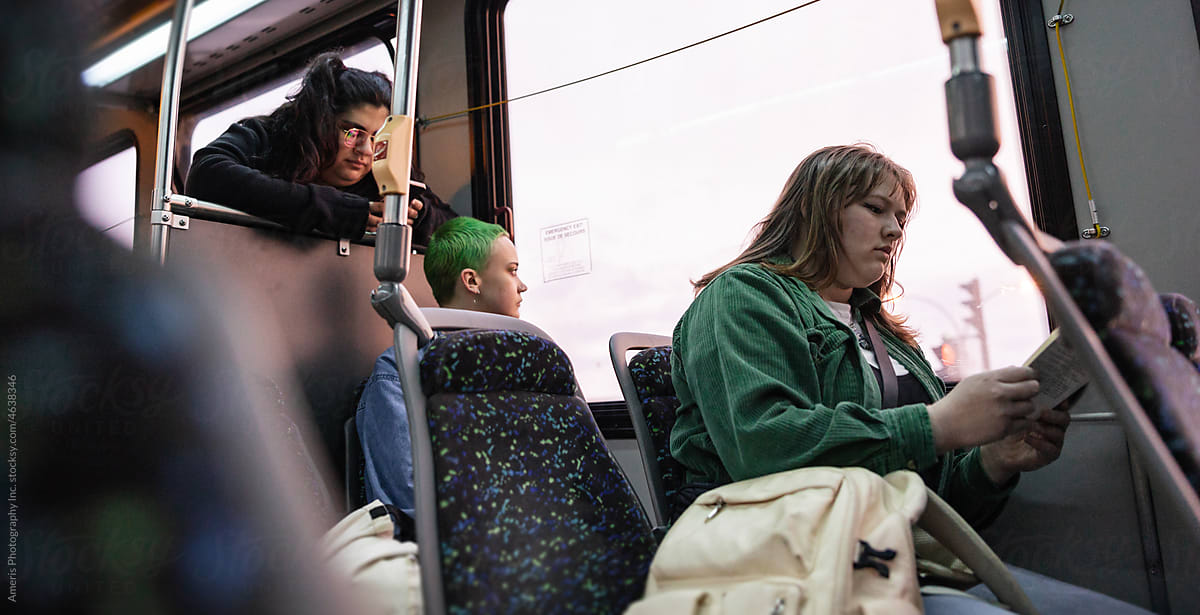 Three friends riding the bus together.