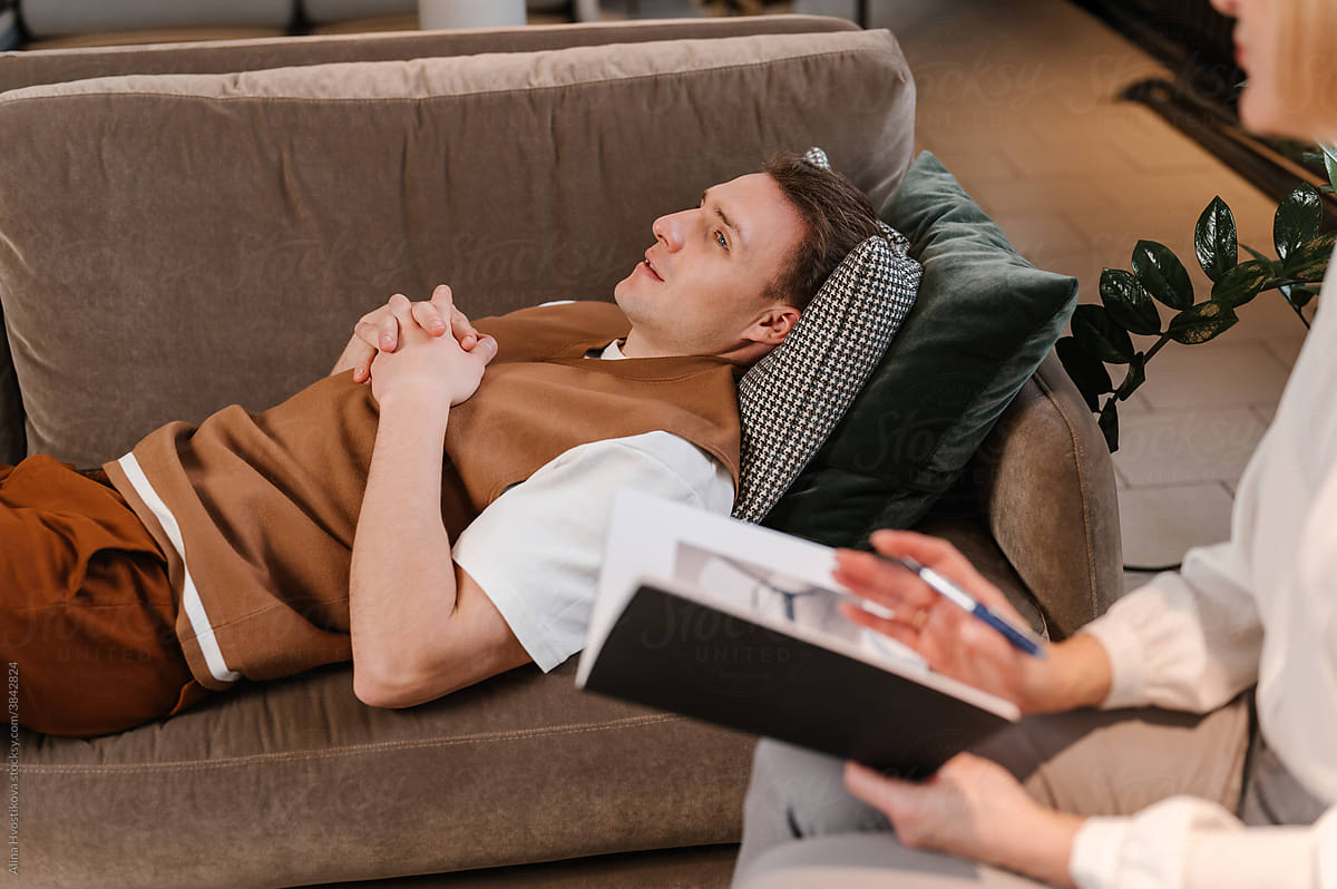 Man lying on sofa during session with psychologist