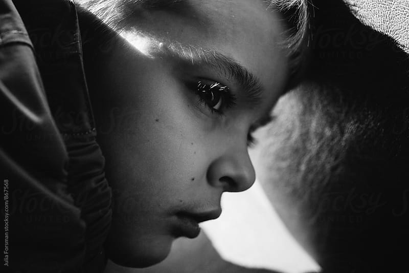 Black and white in which a young boy\'s lashes are lit by the sun.