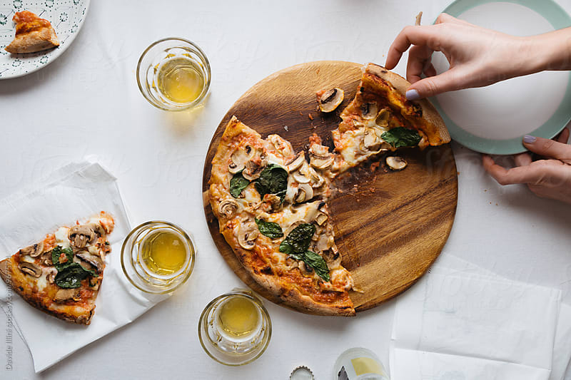 Woman Eating Pizza with mushrooms and basil