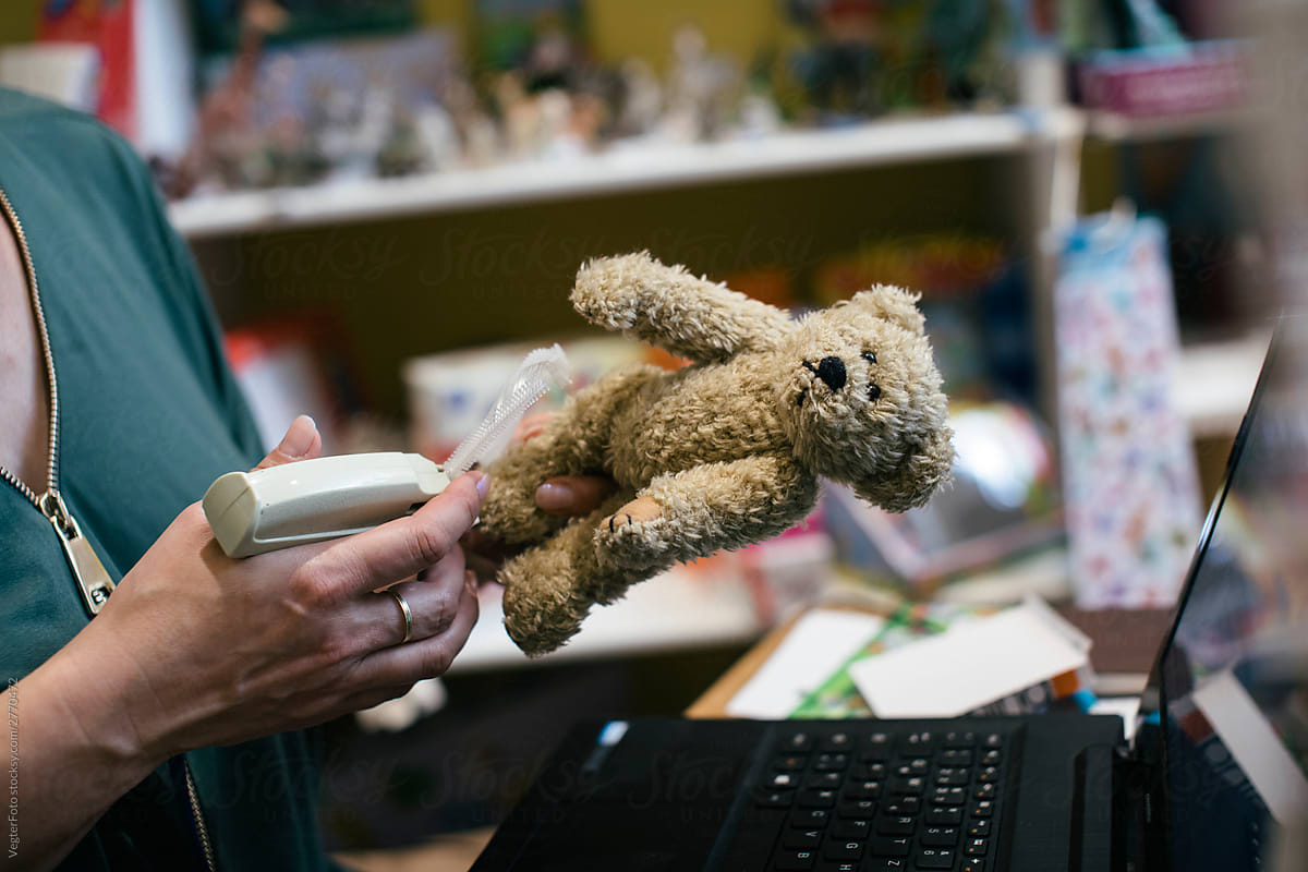 Toy Shop Owner Putting Price Tag On Stuffed Bear