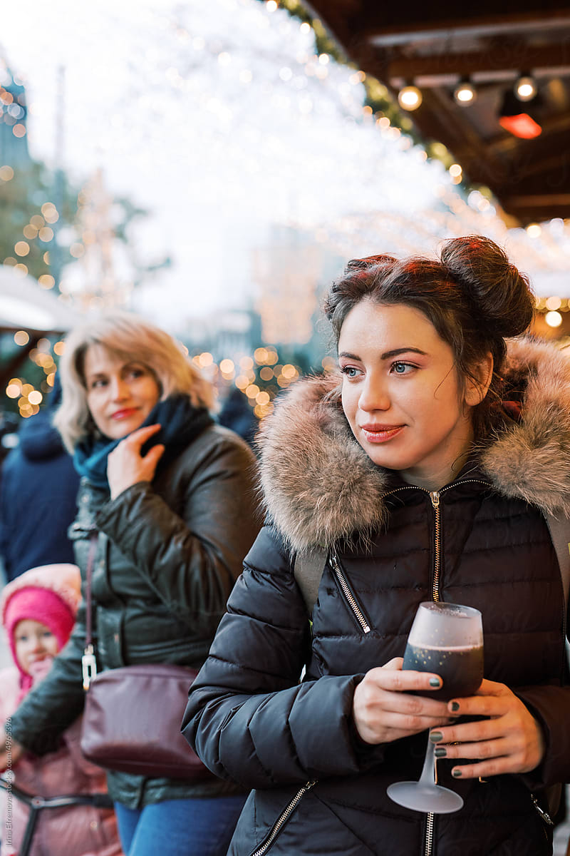 Woman enjoying Mulled Wine with her family on Christmas Market