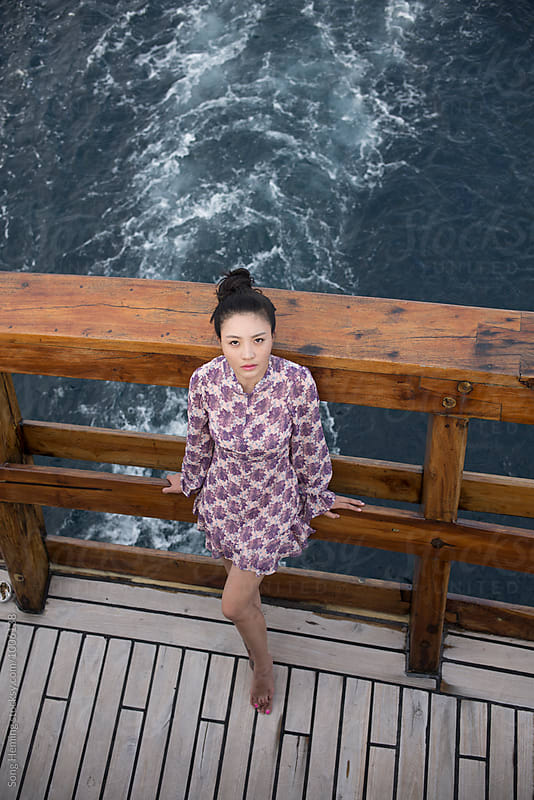 Girl dress up stands on yacht back which driving forward